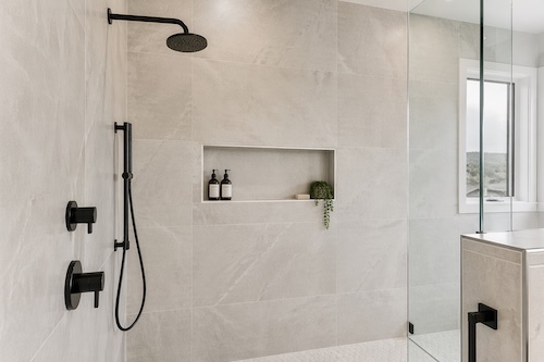 Finished shower wall tile installation in Calgary with large-format porcelain tile, built-in niche, and clean full-height wall coverage